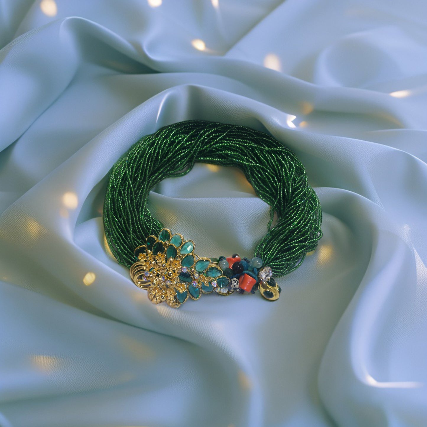 Emerald green beaded statement on a white fabric background